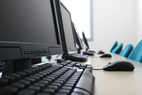 Image of computer monitors with keyboards - Business Insurance
